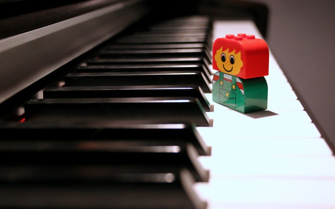 klawisze pianina i figurka z klocków lego na nich